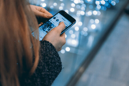 Young girl uses smartphone with Instagram app
