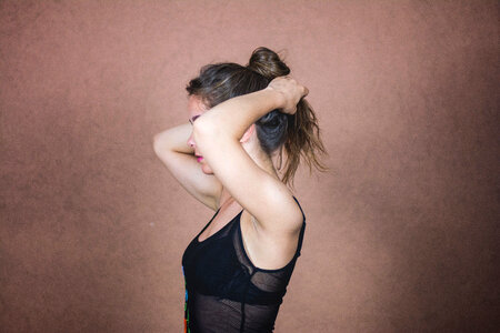 Young Woman Stand Sideways and Bind Her Hair photo