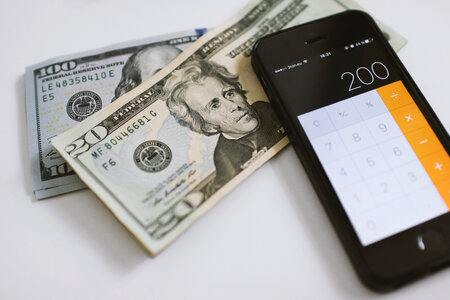 2 Counting Dollars on calculator on smartphone photo