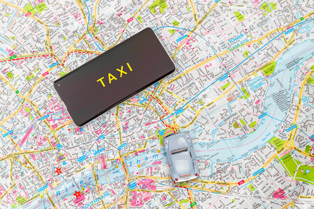 Map with a smartphone and car toy. Taxi concept. photo