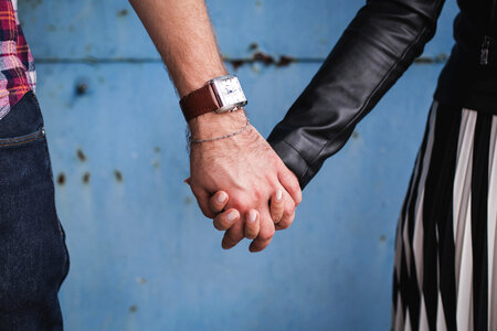 Couple Holding Hands against a Grungy Blue Wall photo