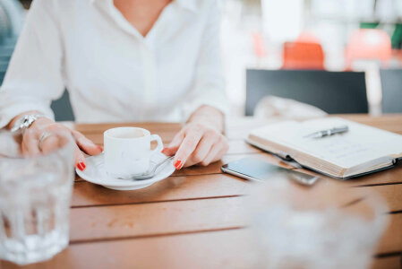 Woman Drinking Coffee with Notepad photo