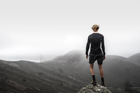 Runner Standing on Top of a Hill and Enjoying View photo