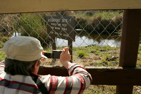 Photographer at Alligators Bite! sign 