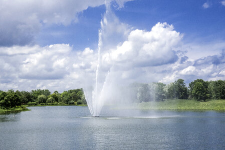 Fountains in the pool under blue sky and clouds at the Chicago Botanical Gardens photo