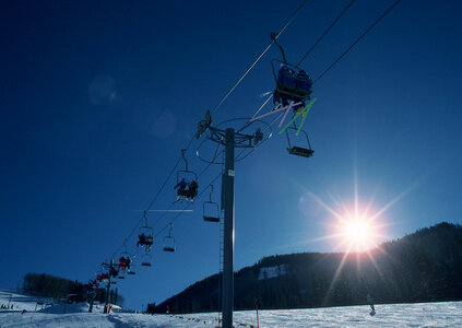 Skiers and snowboarders on a ski lift photo