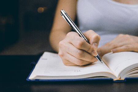 1 The woman’s hand holds a pencil and writes a plan into a diary at home photo