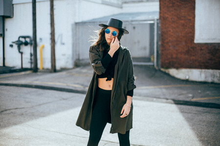 Street Style - Girl Wearing Black Hat and Sunglasses Standing on the Street photo