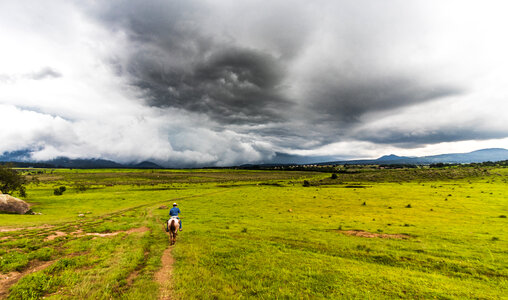 Plains landscape with storm clouds with horse rider photo