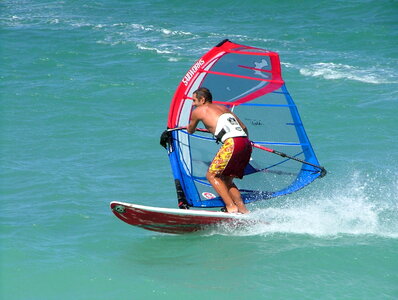 Young man windsurfing with trailing wake photo