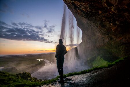 Person standing besides the Waterfall photo