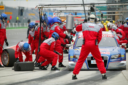 Professional racing team at work during a pitstop of a race car photo