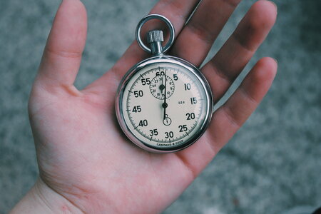 Close Up of Hand Holding Stopwatch Outdoors photo