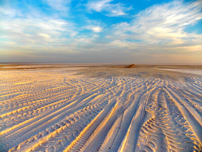 Desert Tracks under blue sky and clouds photo