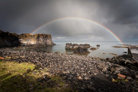 Full Rainbow Over Rocks And Water photo