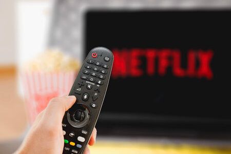 TV remote controller in hand. Watching TV. Netflix streaming services concept.
