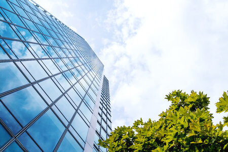 Amazing view from bottom. Windows of office building and sky with clouds photo