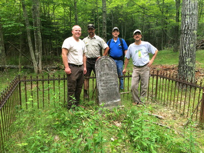 Employees pose by historic grave site at Horicon National Wildlife Refuge