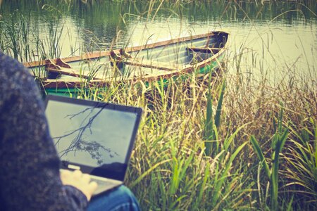 Man on Laptop with Boat