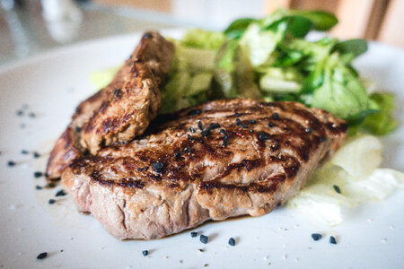 Beef steak with green salad close up photo