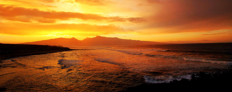 Red Skies and Sunset over mountains and ocean in Hawaii photo