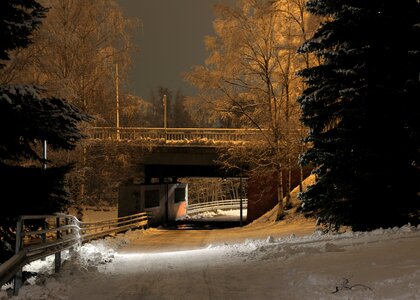 Winter park in the evening covered with snow with a row of lamps