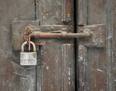 Old rusty padlock on wooden background photo