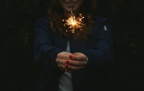 Woman with Red Nails Playing with Sparklers photo