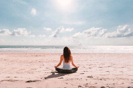 Young woman doing yoga on beach photo
