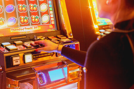 Casino Slot Video Games. Woman Playing Video Slot in the Casino. Hand on Betting Button Closeup Photo. photo