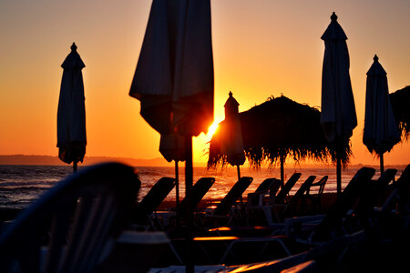 Sunset Silhouettes of Sunbeds and Umbrellas by the Sea photo