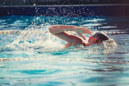 Young man swimming the front crawl in a pool photo