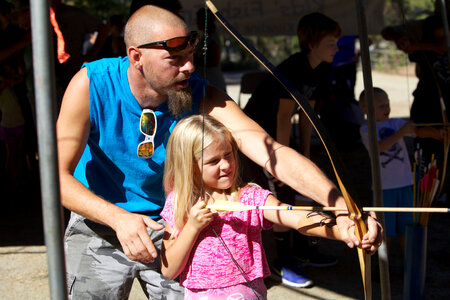 Young girl shooting bow and arrow photo