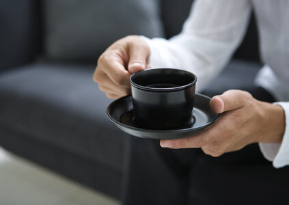 Man having coffee at home, sitting in living room photo