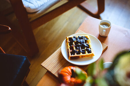 Homemade pumpkin waffle with dark chocolate topping and coffee photo