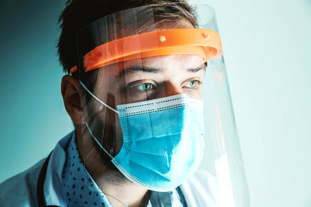 Male Doctor wearing face shield for Coronavirus outbreak or Covid-19. Concept of Covid-19 quarantine. photo