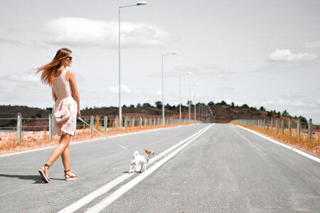 Beautiful Woman Walking with Her Dog on an Empty Road photo