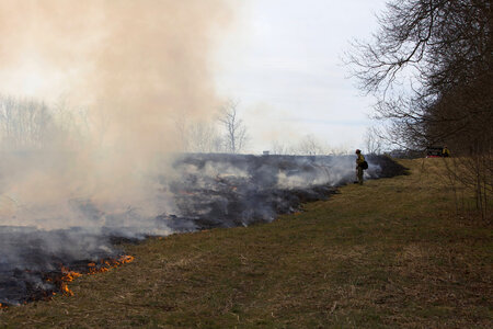 Firefighter along side burning field