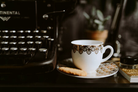 Writing on a typewriter with coffee and biscuit photo