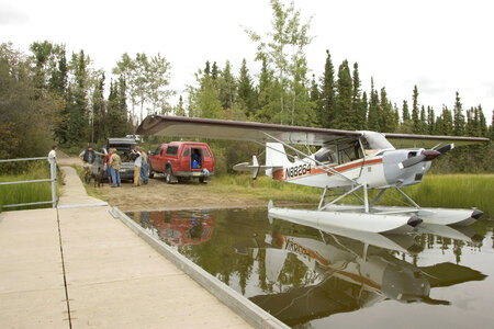Seaplane docked while adults talk with U.S. Fish and Wildlife Service employee at Tetlin National Wildlife Refuge