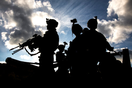 Military silhouettes of soldiers against the backdrop of sunset photo