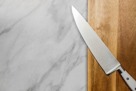 1 Big kitchen knife lying on an old cutting board photo