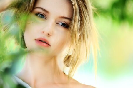 Portrait of Young Beautiful Woman on Green Blurred Background photo