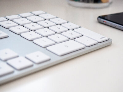 Keyboard and Phone on White Desk photo