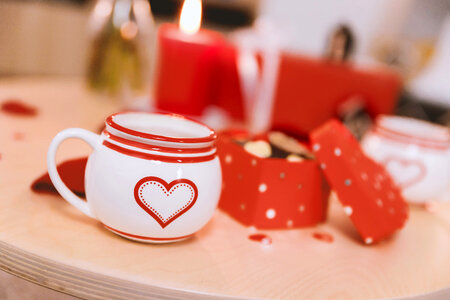 Valentines cup with symbol of love on wooden table. Celebration of Valentine’s Day. photo