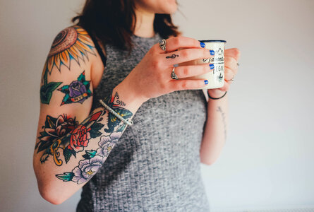 Tattooed Woman Holding a Mug photo