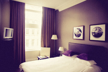 Clean Double Hotel Room with TV and Brown Curtains photo