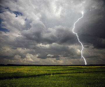 Lightning Strike on the farmland with stormy clouds photo
