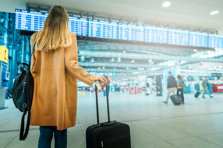 Young woman in coat with luggage at the airport photo