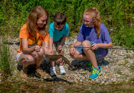 Family fishing, mother nets rainbow trout-3
